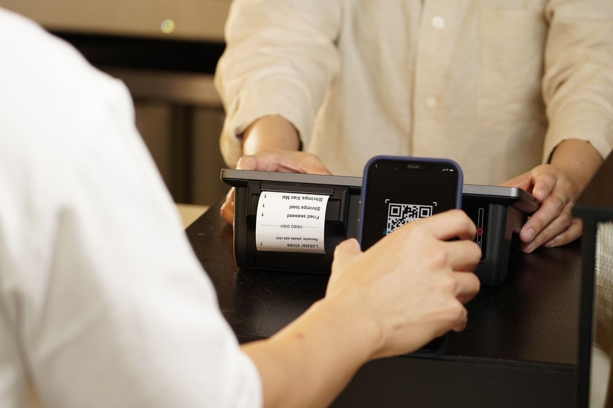 Personnes utilisant un scanner de code-barres sur une machine à tickets lors d'une transaction Personnes utilisant un scanner de code-barres sur une machine à tickets lors d'une transaction